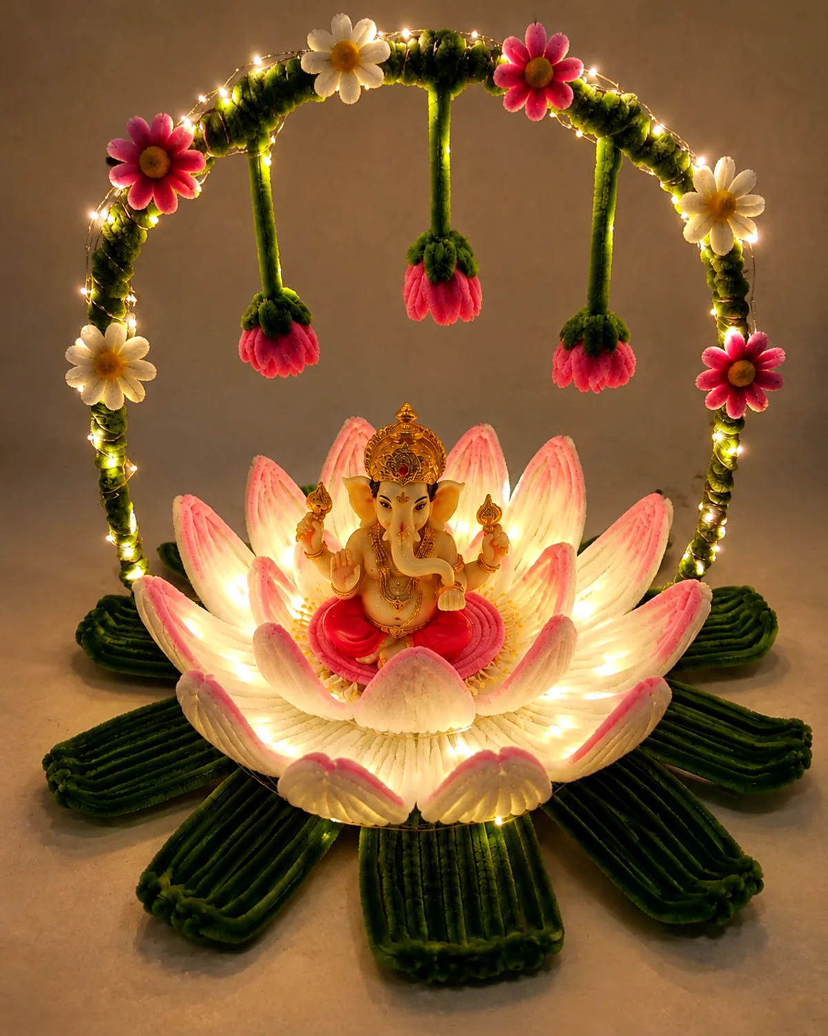 handmade pipe-cleaner lotus under a flowered toran arch, lit with warm LEDs