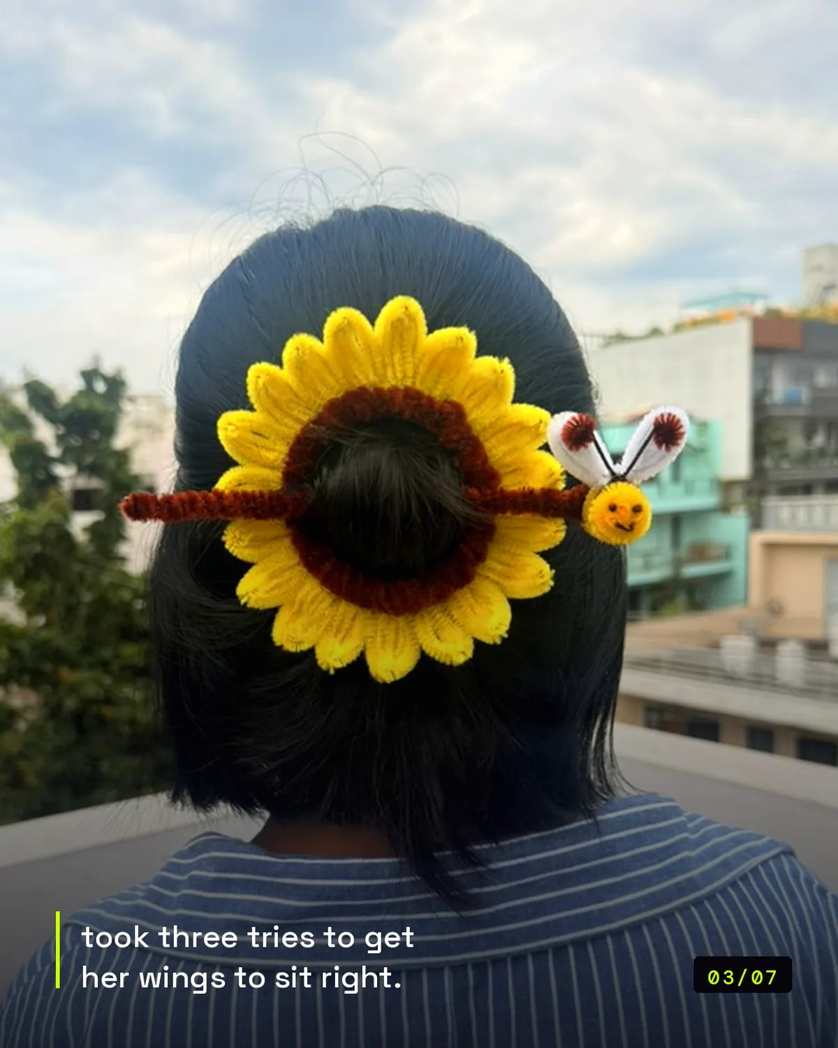 handmade pipe-cleaner sunflower hair clip with a bee, worn in a bun