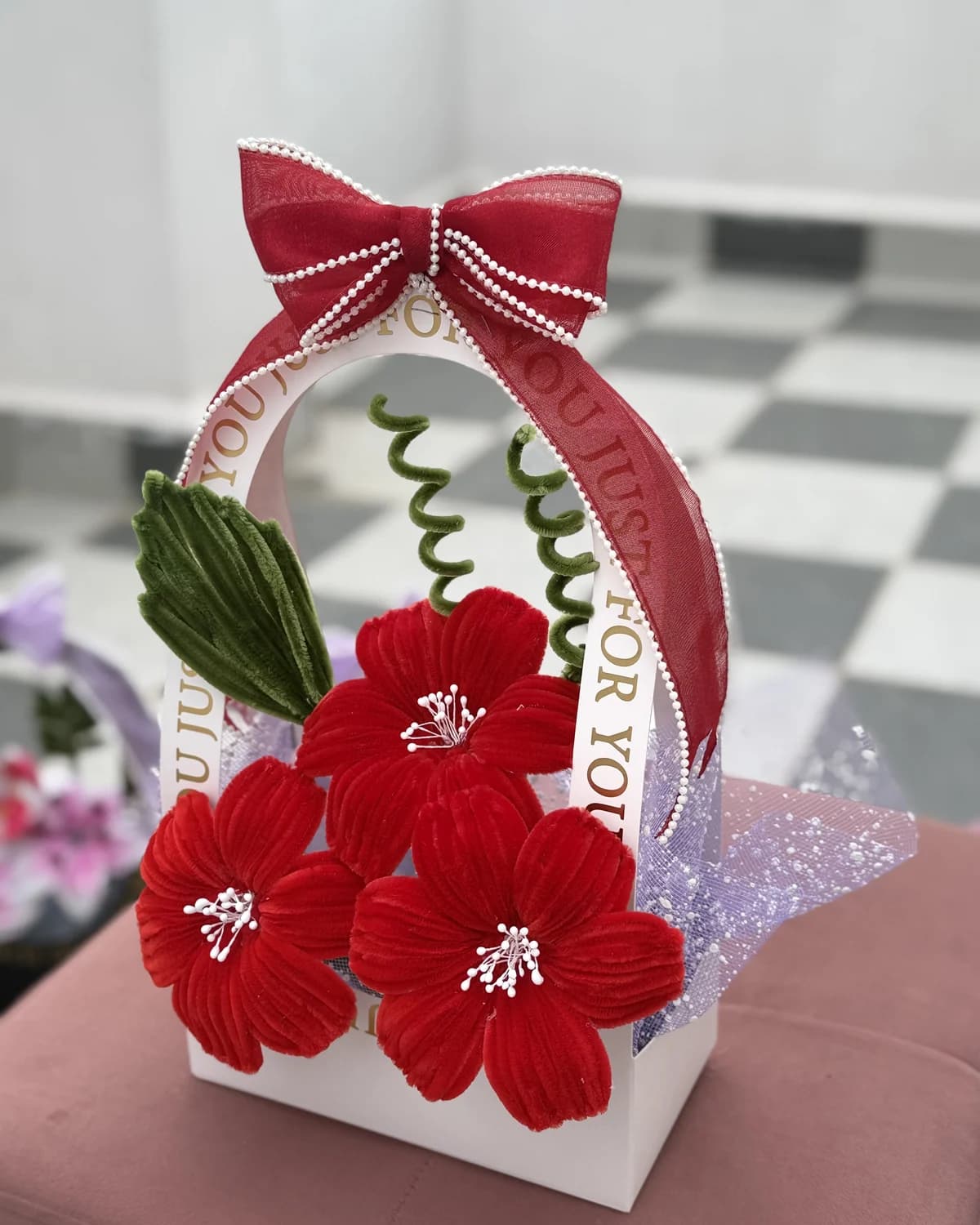 handmade chenille flowers standing in an arched "just for you" carrier bag tied with an organza bow — red blooms, view 3