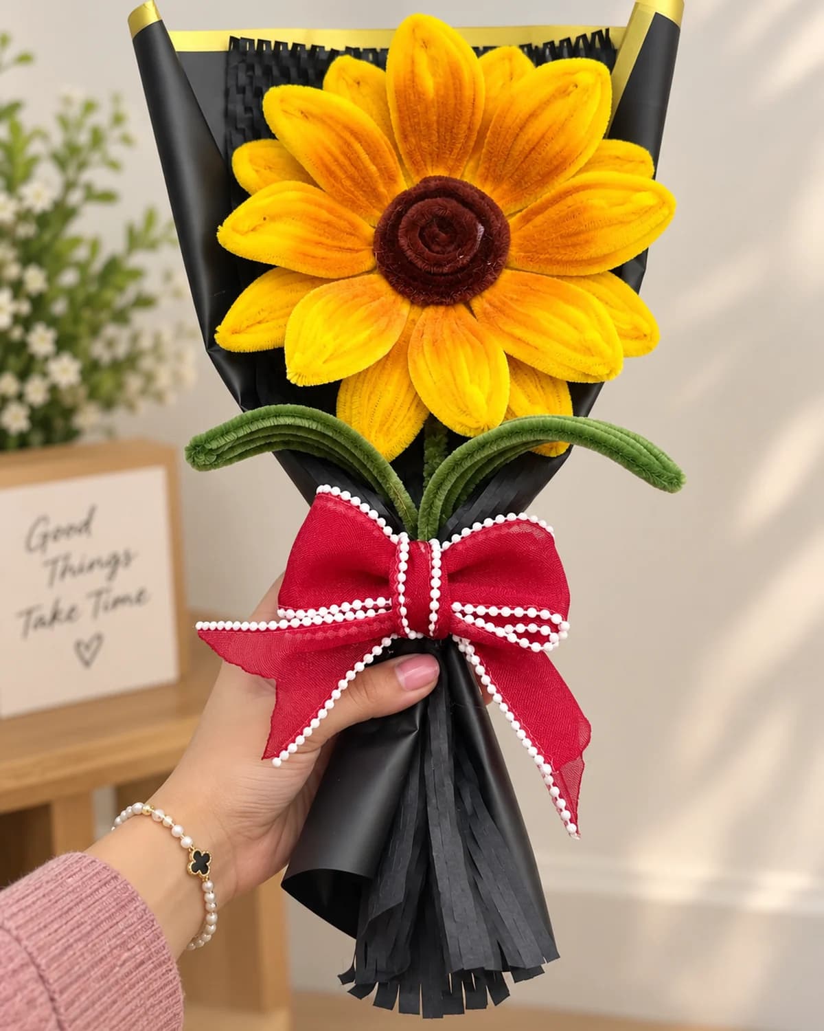 handmade sunflower bouquet wrapped in black paper and tied with a burgundy pearl-edged bow