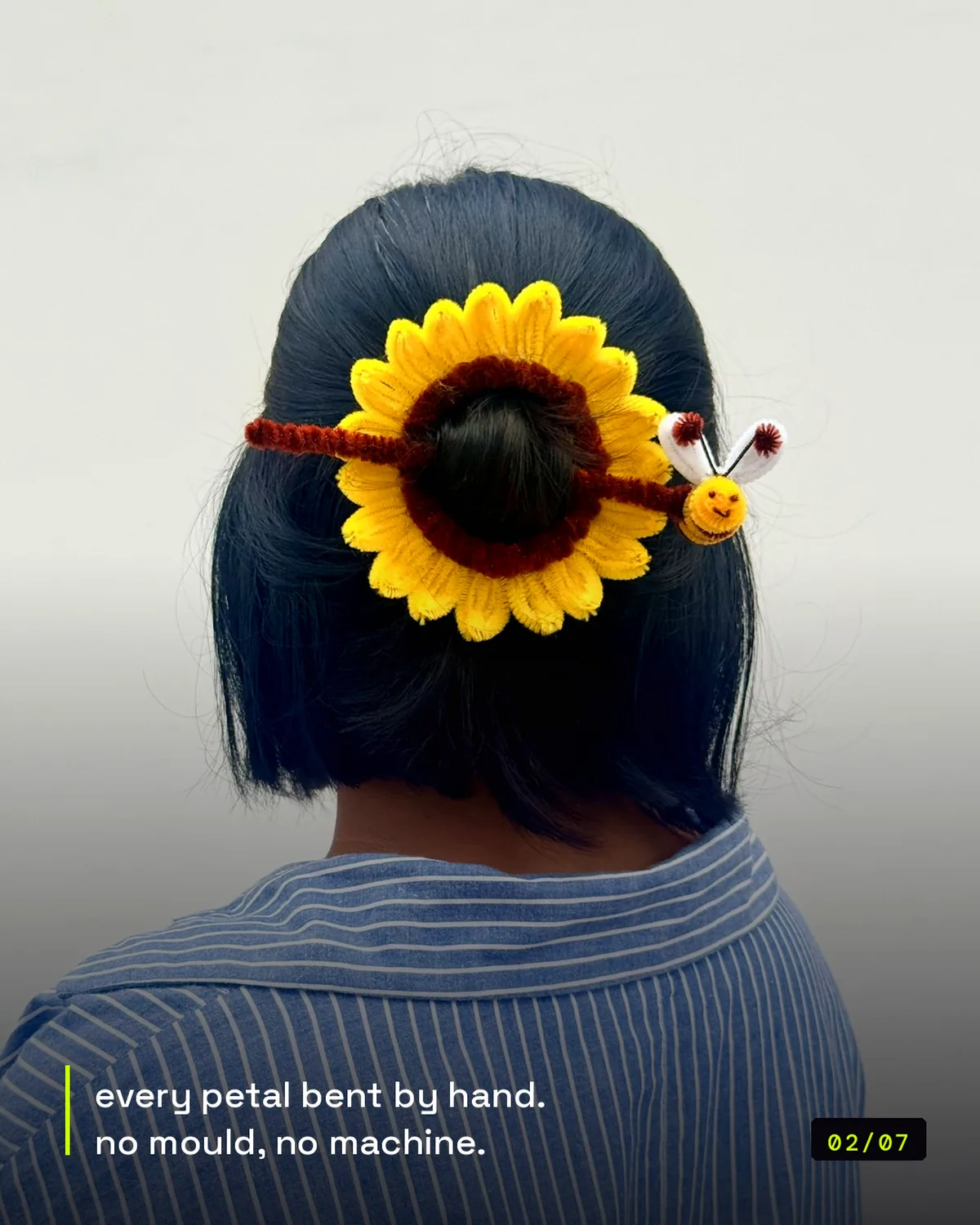 handmade pipe-cleaner sunflower hair clip with a bee, worn in a bun, view 2