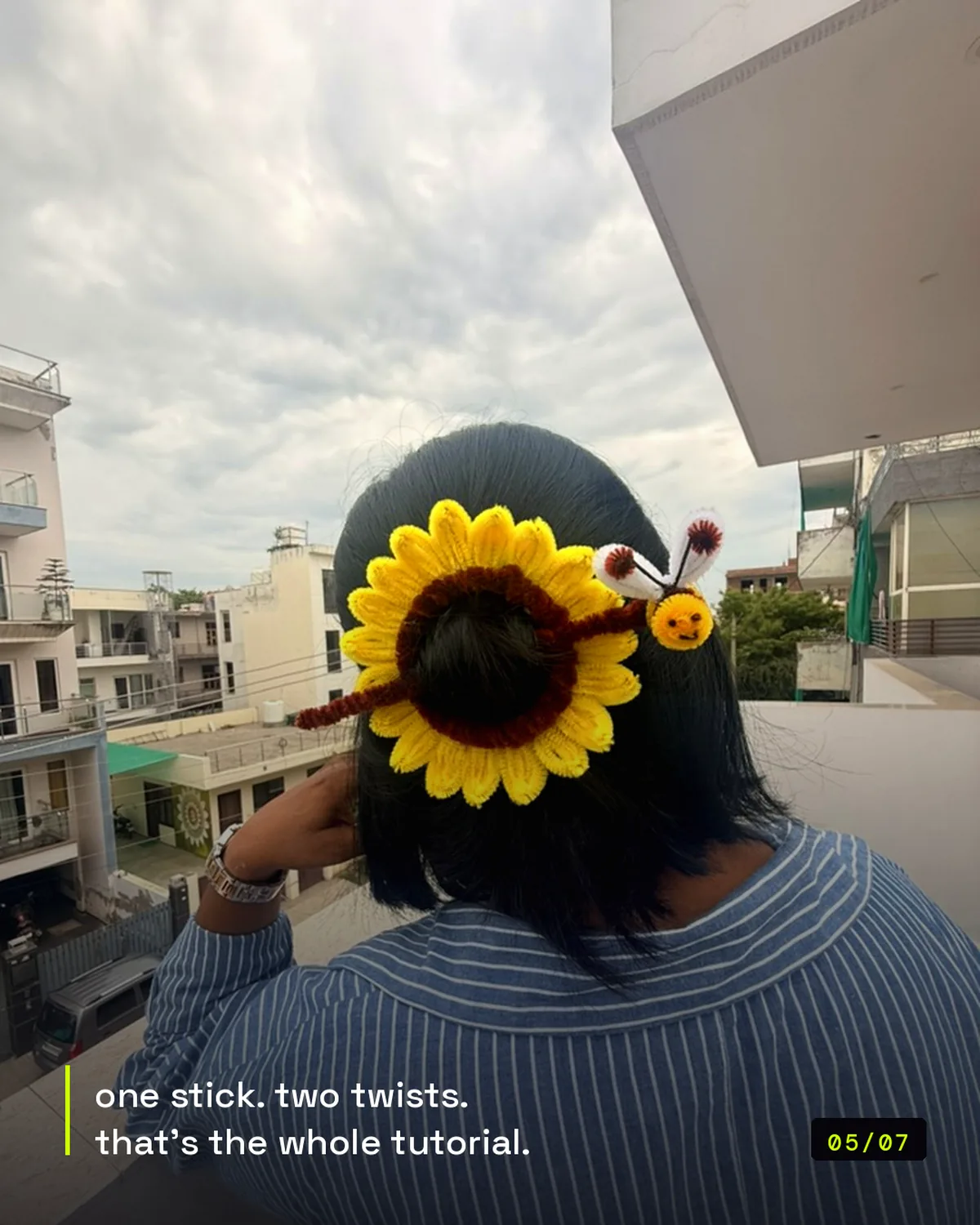 handmade pipe-cleaner sunflower hair clip with a bee, worn in a bun, view 3